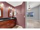 Bathroom features double vanity, burgundy walls, and a view to bedroom at 4613 Painted Cliffs Dr, Las Vegas, NV 89108