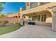 Covered backyard patio, artificial turf, and an arched walkway with a second-story deck at 7943 Sleeping Lily Dr, Las Vegas, NV 89178