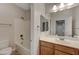 Bathroom with single sink vanity, bathtub with shower, and a tile surround at 7943 Sleeping Lily Dr, Las Vegas, NV 89178