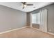 Comfortable bedroom with neutral walls, carpet, a ceiling fan, and a window with white curtains at 7943 Sleeping Lily Dr, Las Vegas, NV 89178
