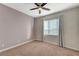 Bright bedroom with brick accent wall, carpet, and a window dressed with gray curtains at 7943 Sleeping Lily Dr, Las Vegas, NV 89178