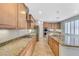 Modern kitchen with granite countertops, stainless steel appliances, and natural wood cabinets with under cabinet lighting at 7943 Sleeping Lily Dr, Las Vegas, NV 89178