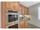 Kitchen area showcasing built-in oven, microwave, granite countertops, wood cabinetry, and tile backsplash at 7943 Sleeping Lily Dr, Las Vegas, NV 89178
