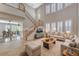 Bright living room features tile flooring, staircase, large windows with shutters, and comfortable sofas, perfect for relaxation at 7943 Sleeping Lily Dr, Las Vegas, NV 89178