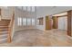 Bright and airy living area features tile flooring, staircase, and large windows with shutters, creating a welcoming atmosphere at 7943 Sleeping Lily Dr, Las Vegas, NV 89178