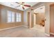 Spacious living room featuring neutral paint, carpet, plantation shutters and a ceiling fan at 7943 Sleeping Lily Dr, Las Vegas, NV 89178