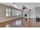 Bright living room with hardwood floors, stacked stone fireplace, and plantation shutters at 7943 Sleeping Lily Dr, Las Vegas, NV 89178
