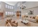 Charming living room showcasing tile floors, staircase, and large windows, complemented by stylish sofas for a comfortable setting at 7943 Sleeping Lily Dr, Las Vegas, NV 89178