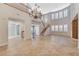 Expansive living room with tile flooring, elegant chandelier, and staircase, ideal for both relaxed living and entertaining guests at 7943 Sleeping Lily Dr, Las Vegas, NV 89178
