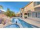 Backyard pool with a rock grotto feature, statue, and second-story patio above at 7943 Sleeping Lily Dr, Las Vegas, NV 89178