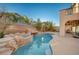 Backyard pool with a grotto, palm trees, and access to an outdoor patio at 7943 Sleeping Lily Dr, Las Vegas, NV 89178