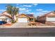 Two-story house with a tan exterior, solar panels, and a white garage door at 6370 Canyon Vista Ct, Las Vegas, NV 89156