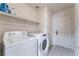 Laundry room with washer, dryer, and overhead shelving at 6370 Canyon Vista Ct, Las Vegas, NV 89156