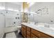 Bathroom with double sinks, oak cabinets, and a shower with glass doors at 6409 Dundock Ave, Las Vegas, NV 89122