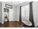 Bright bedroom with wood floors, gray walls, and a cozy chair near the window at 6409 Dundock Ave, Las Vegas, NV 89122