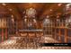Spacious wine cellar with wood paneling, glass-front cabinets, a marble-topped table and seating for eight at 9103 Alta Dr # 401, Las Vegas, NV 89145
