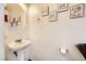 Bright half-bathroom featuring pedestal sink, round mirror, and wall art at 1065 Admiral Emblem St, Henderson, NV 89015