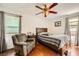 Bedroom with hardwood floors, ceiling fan, and chair at 1065 Admiral Emblem St, Henderson, NV 89015