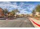 Community entrance featuring wrought iron gates, manicured landscaping, and well-maintained street at 1065 Admiral Emblem St, Henderson, NV 89015