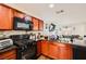 Well-equipped kitchen featuring dark cabinetry, modern appliances, and granite countertops at 1065 Admiral Emblem St, Henderson, NV 89015