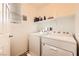 Functional laundry room with washer, dryer, and storage shelving at 1065 Admiral Emblem St, Henderson, NV 89015