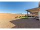 Backyard showcasing a covered patio, artificial grass, and low-maintenance desert landscaping at 10254 Baronia St, Las Vegas, NV 89141