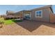 Backyard featuring a covered patio, artificial grass, and desert landscaping for easy maintenance at 10254 Baronia St, Las Vegas, NV 89141