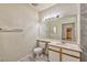 A bright bathroom with a large mirror, vanity, toilet, and tile floor at 4960 Harrison Dr # 214, Las Vegas, NV 89120