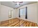 Bright bedroom with wood-look floors, ceiling fan, and access to a bathroom at 4960 Harrison Dr # 214, Las Vegas, NV 89120