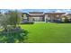 Expansive green backyard with lush landscaping and covered patio with outdoor kitchen at 1 Olympia Canyon Way, Las Vegas, NV 89141
