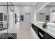 Contemporary bathroom with dual sinks, modern vanity, and a view of the large glass shower and custom storage system at 1 Olympia Canyon Way, Las Vegas, NV 89141