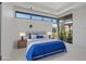 Sunlit bedroom offers large windows, modern décor, and a cozy bed with blue and white bedding at 1 Olympia Canyon Way, Las Vegas, NV 89141