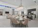 Open-concept dining room features modern light fixture and flows into living room and kitchen at 1 Olympia Canyon Way, Las Vegas, NV 89141