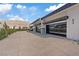 Spacious concrete driveway leads to garages with reflective glass doors at 1 Olympia Canyon Way, Las Vegas, NV 89141