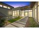 Striking modern home with courtyard, fire feature, and well-lit walkway, creating an inviting outdoor ambiance at 1 Olympia Canyon Way, Las Vegas, NV 89141