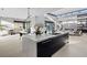 Modern kitchen island featuring a white countertop, black cabinetry, and an open floorplan with living and dining areas at 1 Olympia Canyon Way, Las Vegas, NV 89141