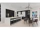 Modern kitchen with a spacious island, breakfast bar, pendant lighting, and an adjacent dining area with seating for six at 1 Olympia Canyon Way, Las Vegas, NV 89141