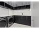 Well-organized laundry room with modern washer and dryer, ample counter space, and sleek cabinetry at 1 Olympia Canyon Way, Las Vegas, NV 89141
