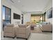 Living room with fireplace, multiple couches, modern decor, and large windows showing backyard views at 1 Olympia Canyon Way, Las Vegas, NV 89141