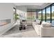 Bright living room with fireplace, modern furnishings, large windows offering views of the landscaped backyard at 1 Olympia Canyon Way, Las Vegas, NV 89141