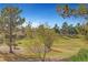 View of the golf course from the backyard with mature trees at 9833 Villa Ridge Dr, Las Vegas, NV 89134