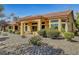 Back exterior of house with landscaped yard, featuring a covered patio and rock garden at 9833 Villa Ridge Dr, Las Vegas, NV 89134