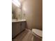 Modern bathroom with gray vanity, white toilet and updated flooring at 2678 Aracatuba Ave, Las Vegas, NV 89121