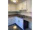 Modern kitchen with white cabinetry, gray countertops, and stainless steel double sink at 5317 Indian River Dr # 295, Las Vegas, NV 89103