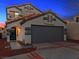 Two-story house with attached garage, illuminated at dusk at 2801 Willow Wind Ct, Las Vegas, NV 89117
