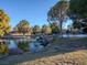 Beautiful pond view with natural rock waterfall feature and manicured landscaping with mature trees at 2801 Willow Wind Ct, Las Vegas, NV 89117