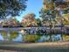 Picturesque pond featuring a natural rock waterfall feature, set amidst mature trees and lush green spaces at 2801 Willow Wind Ct, Las Vegas, NV 89117