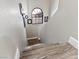 Modern staircase with wood-look flooring and arched window at 2801 Willow Wind Ct, Las Vegas, NV 89117