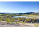 Scenic view of the community featuring a serene pond, lush green spaces, and distant mountains at 44 Strada Caruso, Henderson, NV 89011