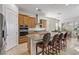 Kitchen with granite countertop island with seating, stainless steel appliances and brown cabinets at 44 Strada Caruso, Henderson, NV 89011